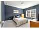 Cozy bedroom with blue accent wall, carpeted floor, window and wooden furniture at 1872 Commons Nw Pl, Atlanta, GA 30318