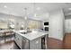 Open-concept kitchen with island overlooking the living room, stainless appliances, and hardwood floors at 1872 Commons Nw Pl, Atlanta, GA 30318