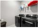 Modern laundry room with front-load washer and dryer and storage shelf at 1872 Commons Nw Pl, Atlanta, GA 30318