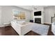 Bright living room featuring a fireplace, ceiling fan, large window and comfortable white couch at 1872 Commons Nw Pl, Atlanta, GA 30318