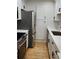 Galley kitchen features stainless steel appliances, white cabinetry and stone countertops at 2201 Pine Heights Ne Dr, Atlanta, GA 30324