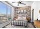 Cozy bedroom with exposed brick wall, ceiling fan, and large window offering neighborhood views at 2626 Peachtree Nw Rd # 1102, Atlanta, GA 30305