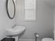 This half-bathroom features modern fixtures, a pedestal sink, and a framed mirror at 5512 Cascade Sw Run, Atlanta, GA 30336