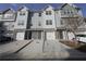 Three-story townhomes featuring attached garages and modern exteriors with gray siding and stone accents at 951 Plaza Park Walk # 50, Kennesaw, GA 30144