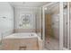 Bathroom featuring a jetted tub with tile surround and glass enclosed shower at 955 Golf View Ct, Dacula, GA 30019