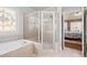 Elegant bathroom featuring a jetted tub, separate shower, and decorative glass window at 955 Golf View Ct, Dacula, GA 30019
