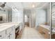 Bright bathroom with double sinks, vanity, soaking tub, and neutral tile flooring at 955 Golf View Ct, Dacula, GA 30019