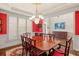Formal dining room with red walls, large shutters, and a view of the entryway at 955 Golf View Ct, Dacula, GA 30019