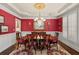 Formal dining room featuring red walls, a chandelier, and seating for eight at 955 Golf View Ct, Dacula, GA 30019