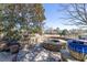 Charming stone firepit with built-in seating surrounded by a stone patio and landscaping at 955 Golf View Ct, Dacula, GA 30019