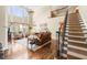Spacious living room with large windows, fireplace, hardwood floors, staircase and plenty of natural light at 955 Golf View Ct, Dacula, GA 30019