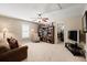A cozy living room includes a couch, bookshelf, ceiling fan, and doorway leading to an exercise area at 955 Golf View Ct, Dacula, GA 30019