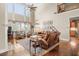 Spacious living room featuring tall windows, a ceiling fan, and leather furniture at 955 Golf View Ct, Dacula, GA 30019