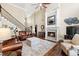 Elegant living room with a fireplace, staircase, ceiling fan, and comfortable leather furniture at 955 Golf View Ct, Dacula, GA 30019