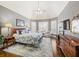 Comfortable main bedroom with a tray ceiling, plush bedding, and plenty of natural light at 955 Golf View Ct, Dacula, GA 30019