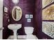 Stylish powder room features a pedestal sink, oval mirror, decorative wall art, and purple walls at 955 Golf View Ct, Dacula, GA 30019