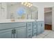 Bathroom with dual sinks, light blue cabinetry, a large mirror and a view of the walk-in shower at 2075 Pine Tree Dr # D4, Buford, GA 30518
