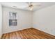 Cozy bedroom featuring hardwood floors, a ceiling fan, and a large window offering ample natural light at 2075 Pine Tree Dr # D4, Buford, GA 30518