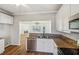Well-lit kitchen featuring granite countertops, stainless steel appliances, and a view of the fireplace in the living room at 2075 Pine Tree Dr # D4, Buford, GA 30518