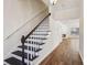 Inviting home staircase with dark wood stairs and white risers, leading to the upper level and views of the living area at 2075 Pine Tree Dr # D4, Buford, GA 30518