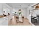 Modern eat-in kitchen featuring a wood dining table, woven pendant light, and access to the main living area at 5079 N Dogwood Hills Dr, Buford, GA 30518