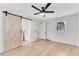 Bedroom with ceiling fan, bathroom, and closet with wood flooring at 5079 Ne Dogwood Hills Dr, Buford, GA 30518