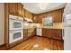 Traditional kitchen featuring wood cabinets, double ovens, and hardwood floors at 755 Rounsaville Rd, Roswell, GA 30076