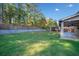 The expansive backyard features lush green grass, mature trees, a gazebo, a tall fence, and a covered patio at 1118 Reddy Farm Rd, Grayson, GA 30017