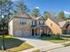 Two story brick home with well maintained lawn and landscaping, two-car garage, and a covered front entrance at 1118 Reddy Farm Rd, Grayson, GA 30017