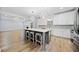 Bright, open-concept kitchen featuring a gray island with seating and stainless steel appliances at 1118 Reddy Farm Rd, Grayson, GA 30017