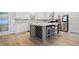 Bright kitchen with stainless steel appliances, gray island with seating, and decorative backsplash at 1118 Reddy Farm Rd, Grayson, GA 30017