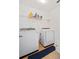 This laundry room offers a washer, dryer, and storage shelf, providing practicality for daily tasks and organization at 1118 Reddy Farm Rd, Grayson, GA 30017