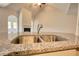 Focus on a stainless-steel sink with granite countertops and a glimpse of the living room at 700 Park Place Way, Social Circle, GA 30025