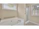 Bathroom featuring a large soaking tub and separate glass-enclosed shower with safety bars at 1150 Strath Clyde Way, Mcdonough, GA 30253