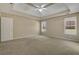 Light-filled main bedroom with tray ceiling, carpet flooring, and multiple windows at 1150 Strath Clyde Way, Mcdonough, GA 30253