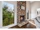 Stone fireplace with a hearth, flanked by large windows, and hardwood flooring at 501 Brook Hollow Se Cir, Marietta, GA 30067