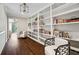 Hallway with wall of white built-in bookshelves and two club chairs at 501 Brook Hollow Se Cir, Marietta, GA 30067