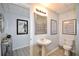 Bathroom featuring a pedestal sink, a framed mirror, and inspirational wall art at 545 Cotton Gin Ln, Lawrenceville, GA 30045