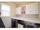 Functional laundry room with modern washer and dryer, countertop, and storage cabinets at 545 Cotton Gin Ln, Lawrenceville, GA 30045