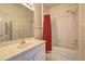 Well-lit bathroom with a combination tub and shower, vanity, and charming polka dot wallpaper at 1225 Sand Knoll Sw Run, Lilburn, GA 30047