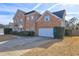 A brick home with a well-manicured lawn, an attached garage, and a paved driveway at 1225 Sand Knoll Sw Run, Lilburn, GA 30047