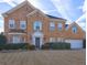 Charming brick home showcasing a well-maintained lawn, mature landscaping and attached garage at 1225 Sand Knoll Sw Run, Lilburn, GA 30047