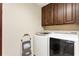 Well-lit laundry room with washer, dryer and brown cabinets at 1350 Bluestone Dr, Cumming, GA 30041