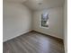 A bedroom featuring a window, neutral walls, and lovely wood-look floors at 207 Autumn Lake Way, Mcdonough, GA 30253