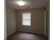 This bedroom features a neutral color palette and a sunlit window, creating a cozy and inviting space at 2627 Evans Mill Dr, Lithonia, GA 30058