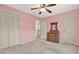 Bedroom with light pink walls, a window, ceiling fan, dresser and closet at 4314 Deep Springs Nw Ct, Kennesaw, GA 30144