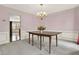Formal dining room with pink walls, decorative trim, chandelier, and neutral carpet at 4314 Deep Springs Nw Ct, Kennesaw, GA 30144
