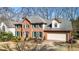 Two-story brick home featuring a two-car garage, manicured landscaping, and an American flag at 4314 Deep Springs Nw Ct, Kennesaw, GA 30144
