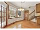 Sunny kitchen nook with hardwood floors, wooded view, stairs to basement, and access to the outdoor deck at 4314 Deep Springs Nw Ct, Kennesaw, GA 30144