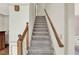 Carpeted stairway with stained wood handrail and painted trim at 4314 Deep Springs Nw Ct, Kennesaw, GA 30144